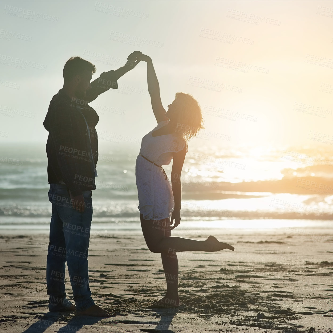 Buy stock photo Shot of an affectionate young couple enjoying their time on the beach