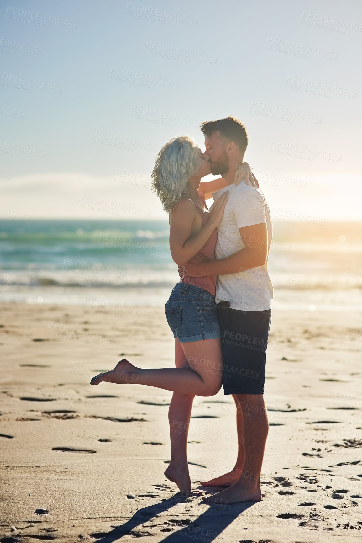 Buy stock photo Love, couple and kiss at beach on holiday, travel or summer vacation outdoor in nature. Romance, man and woman at sea together for connection, support and commitment to healthy relationship by ocean