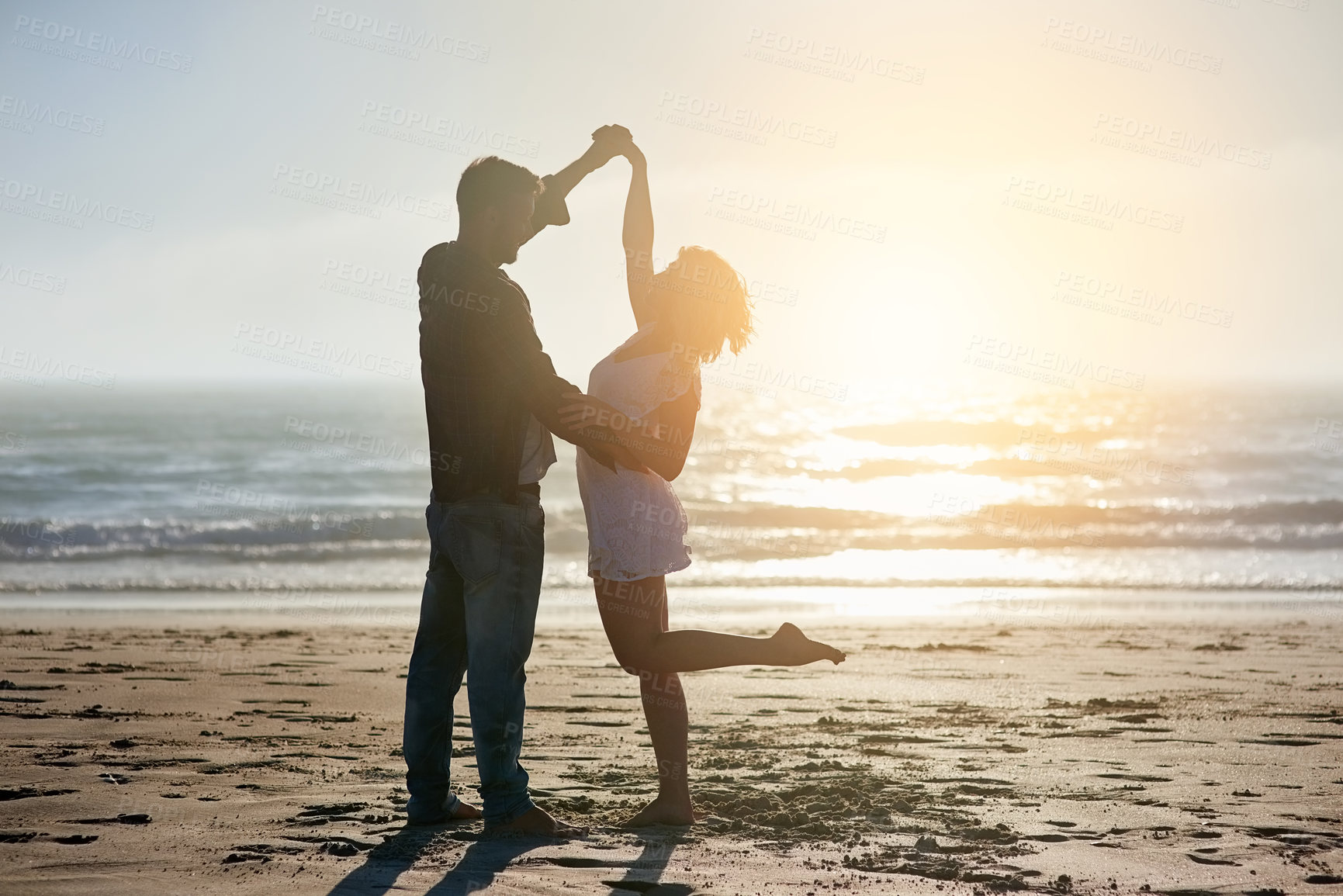 Buy stock photo Love, sunset and couple dance at beach on holiday, travel or summer vacation outdoor in nature. Romance, man and woman holding hands at sea together for connection, support and celebration at ocean