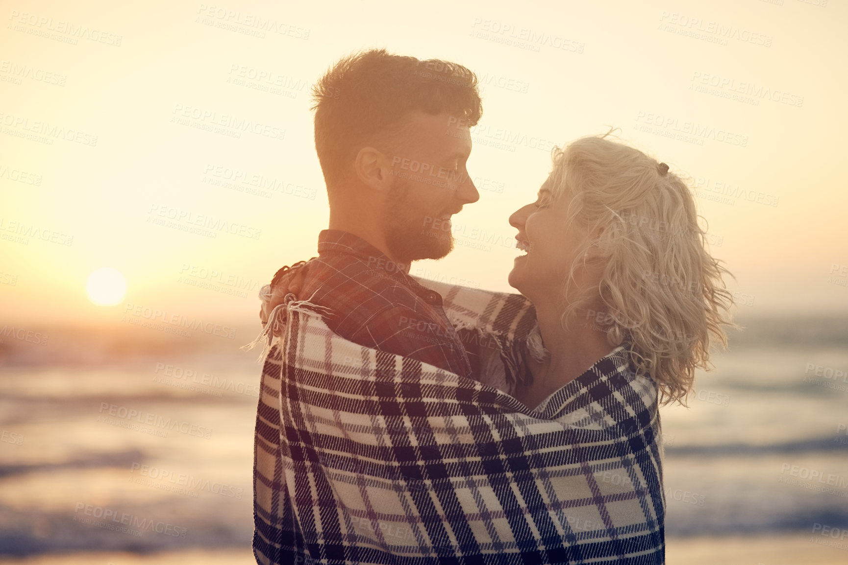 Buy stock photo Cropped shot of an affectionate young couple enjoying their time on the beach