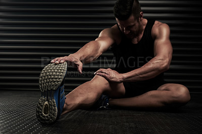 Buy stock photo Studio shot of an athletic young man warming up before a workout