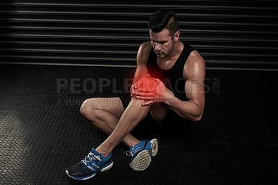 Buy stock photo High angle shot of an athletic young man working out with an injury in the studio
