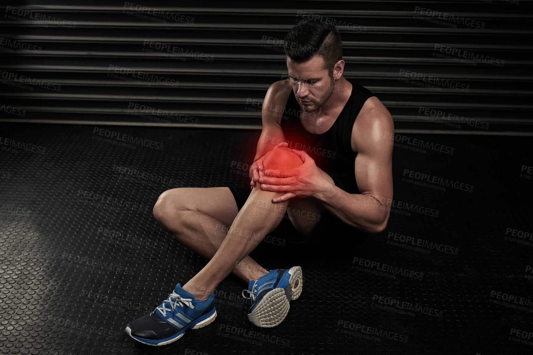 Buy stock photo High angle shot of an athletic young man working out with an injury in the studio