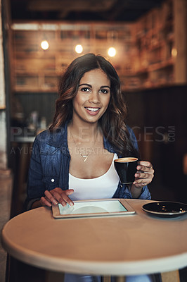 Buy stock photo Portrait of a relaxed young woman using her tablet in a coffee shop