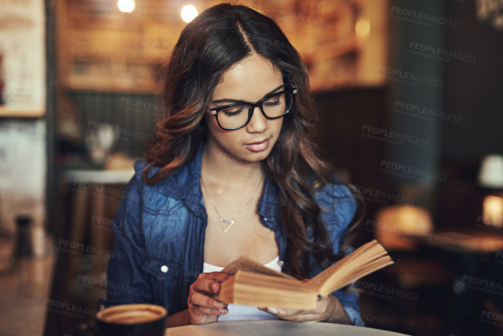 Buy stock photo Cafe, woman and reading book at table with coffee to relax, entertainment or story in morning. Student, learning and female person with university textbook for information, knowledge or studying