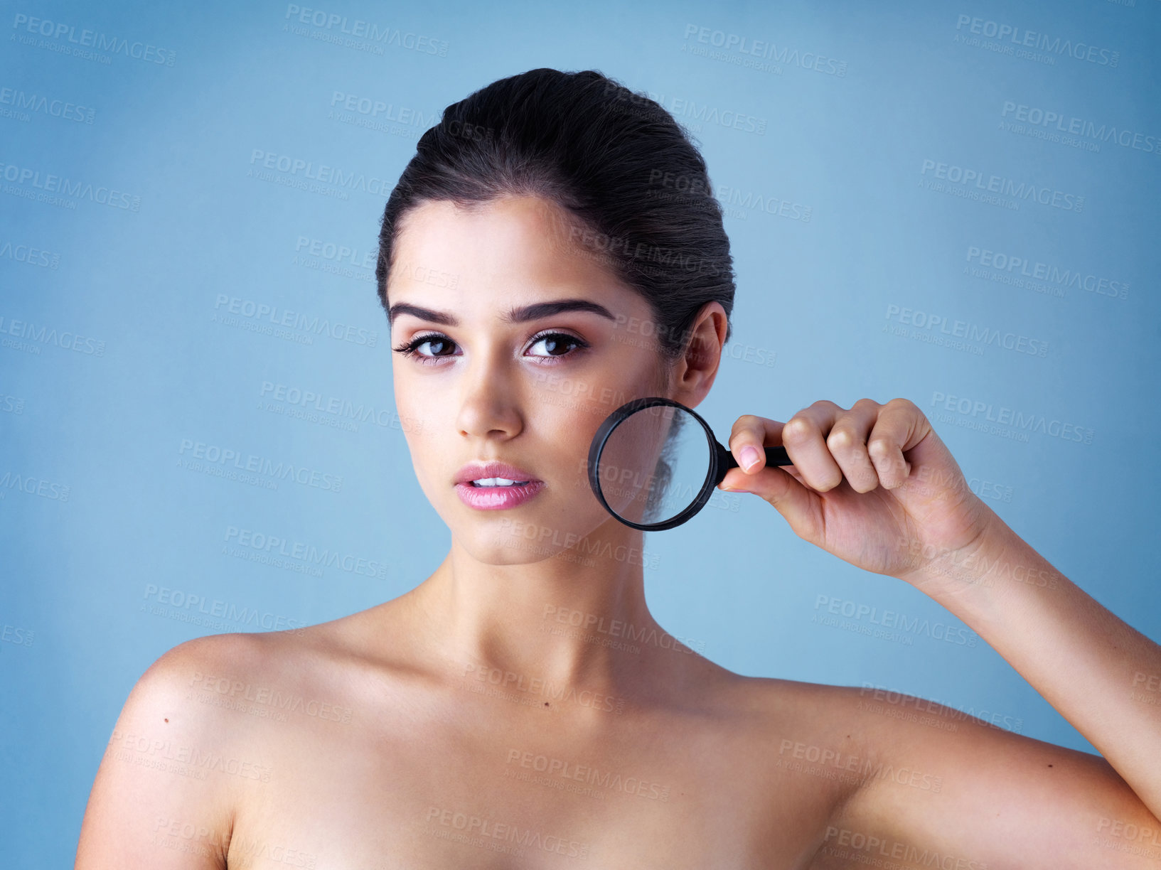 Buy stock photo Skincare, portrait and woman with magnifying glass in studio for wellness, treatment or results inspection on blue background. Skin, magnifier or beauty model with face search for dermatology benefit