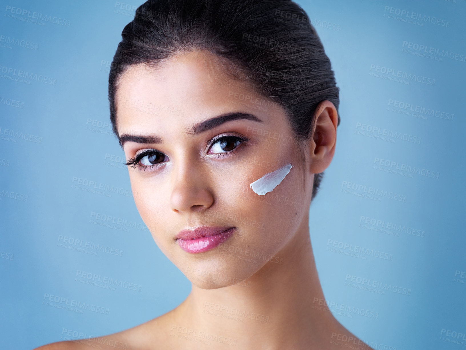 Buy stock photo Skincare, portrait or woman with face cream application in studio for wellness, glow or repair on blue background. Beauty, sunscreen or model with facial product for cleaning, detox or makeup removal