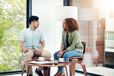 Buy stock photo Shot of two creative colleagues sharing ideas in their office