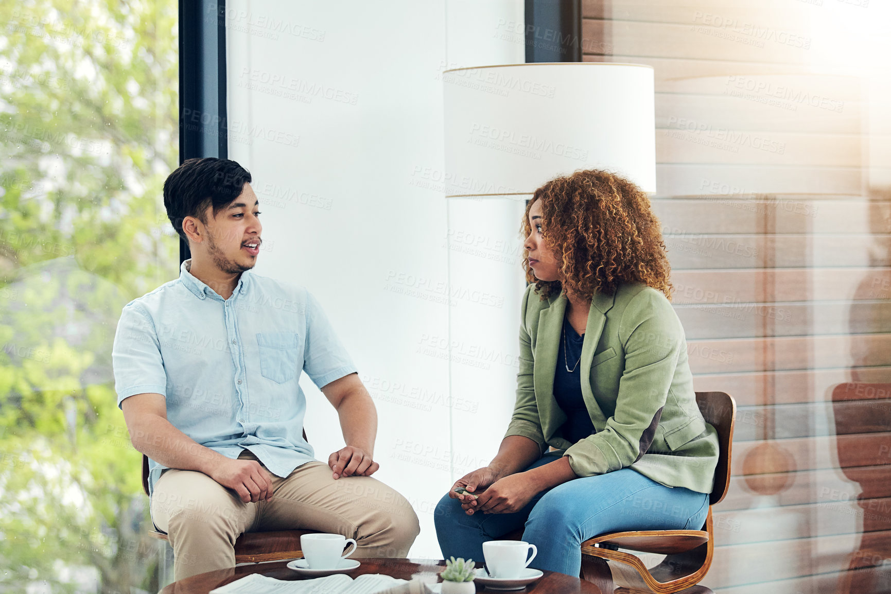 Buy stock photo Shot of two creative colleagues sharing ideas in their office