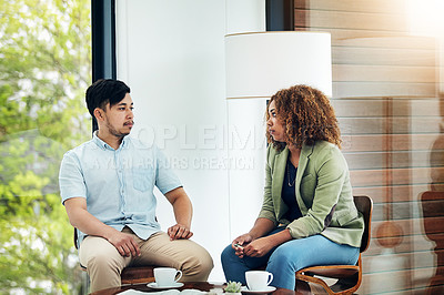Buy stock photo Shot of two creative colleagues sharing ideas in their office