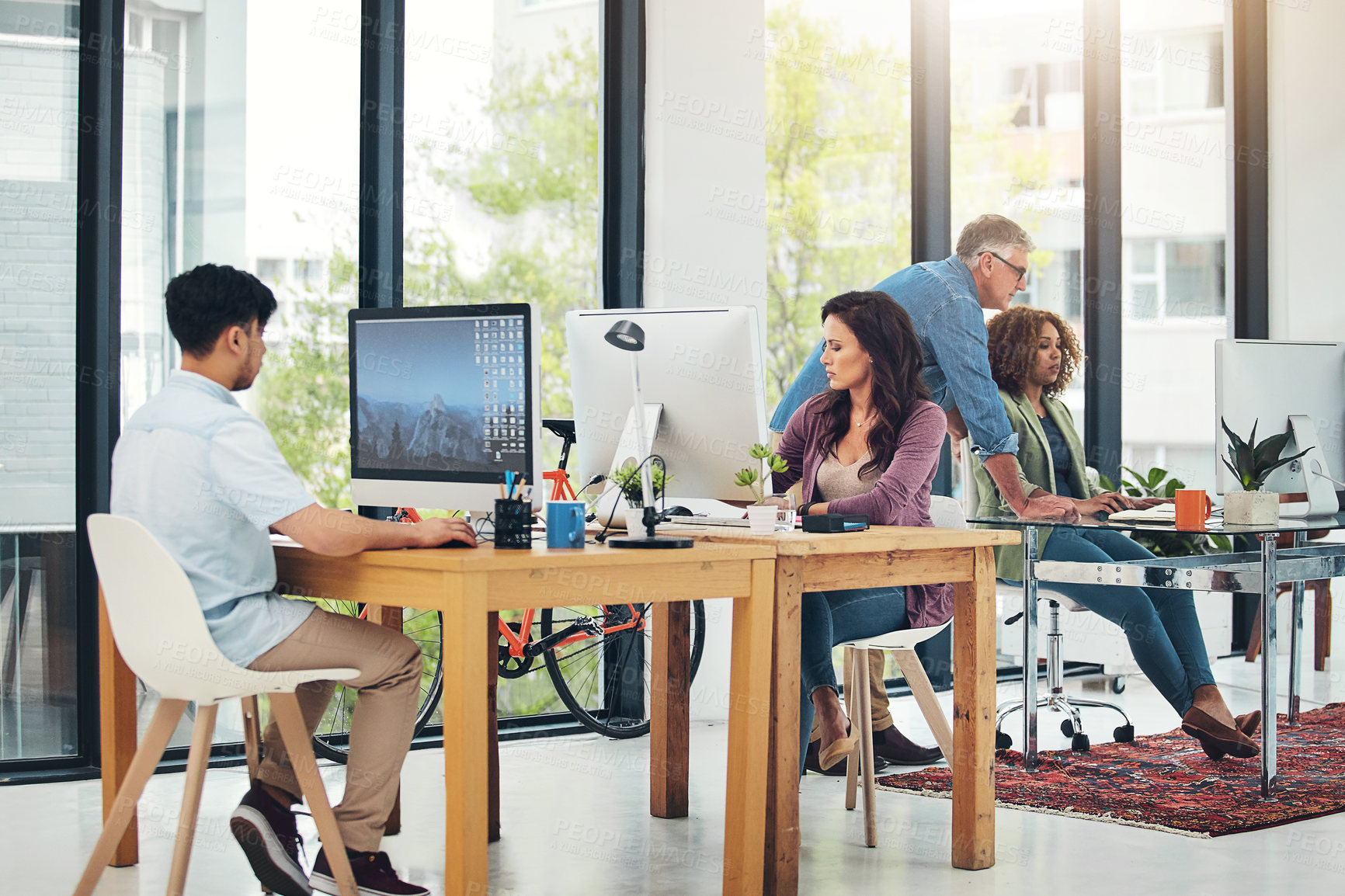 Buy stock photo Shot of group of creative colleagues working on a project together in their office