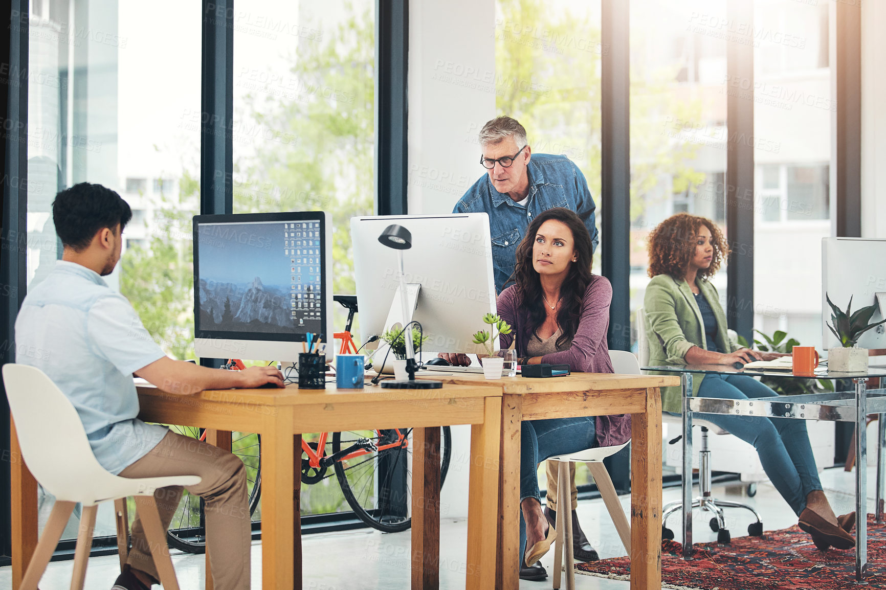 Buy stock photo Shot of group of creative colleagues working on a project together in their office