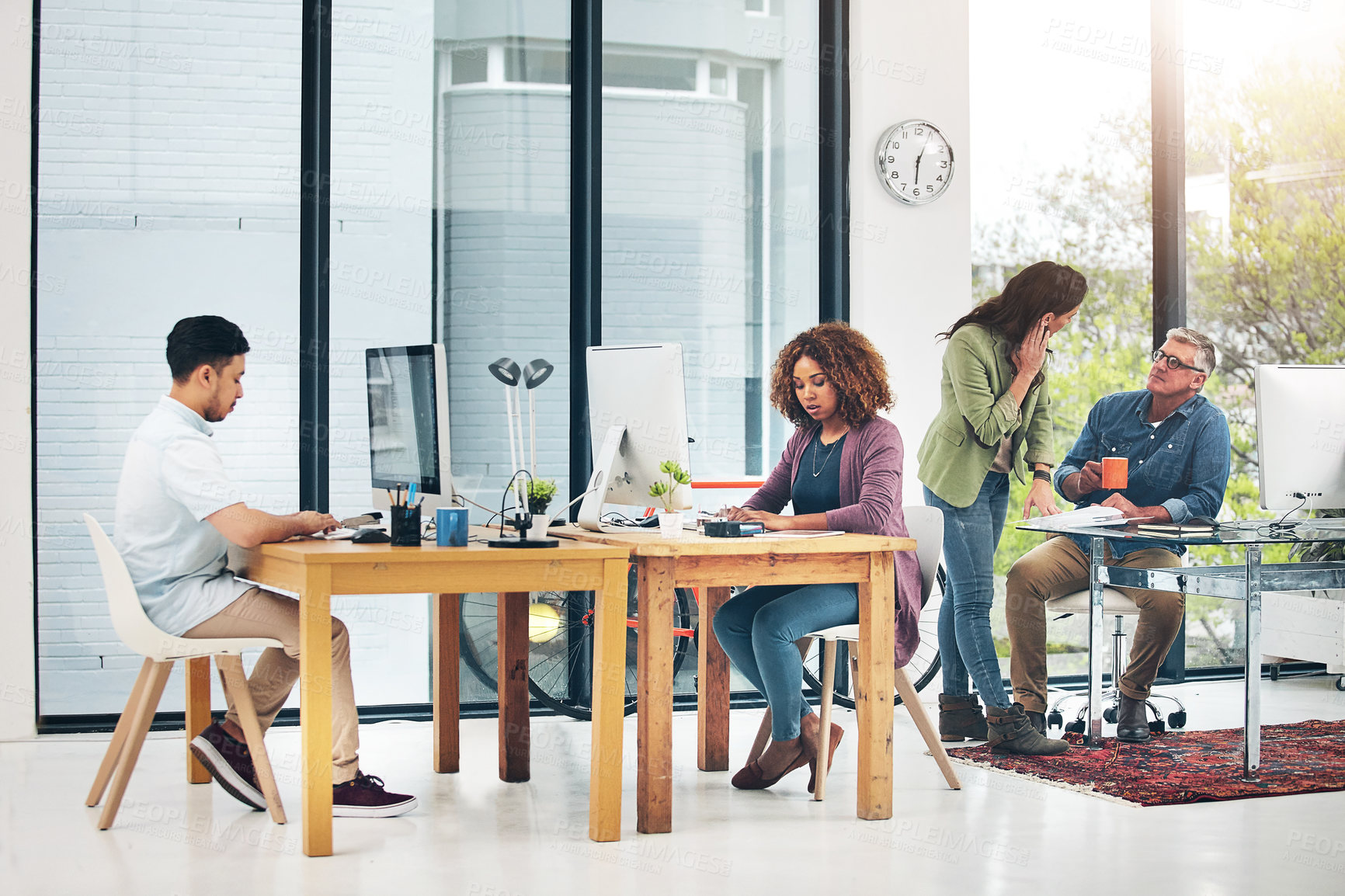 Buy stock photo Shot of group of creative colleagues working on a project together in their office