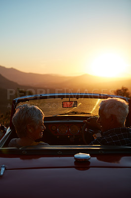 Buy stock photo Shot of a senior couple enjoying the sunset during a roadtrip