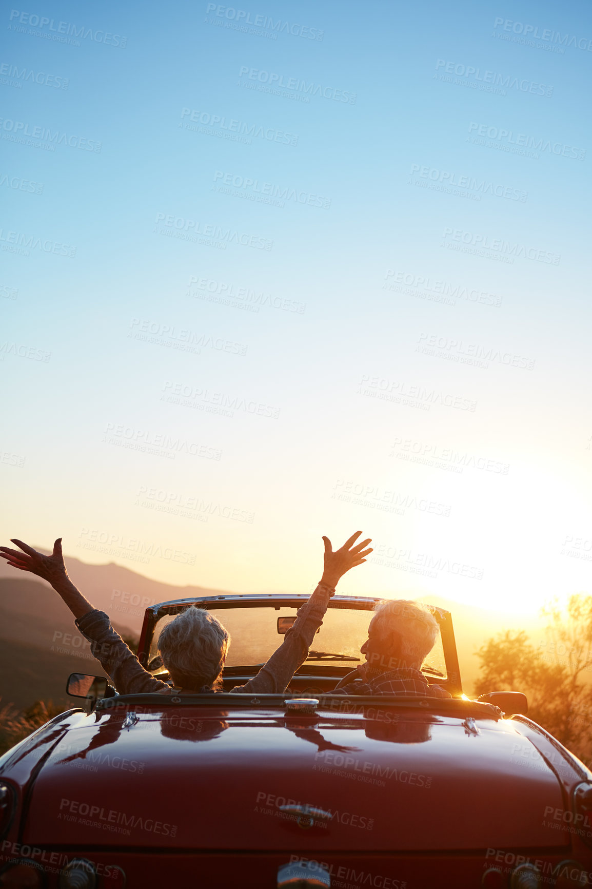 Buy stock photo Shot of a joyful senior couple enjoying the sunset during a roadtrip