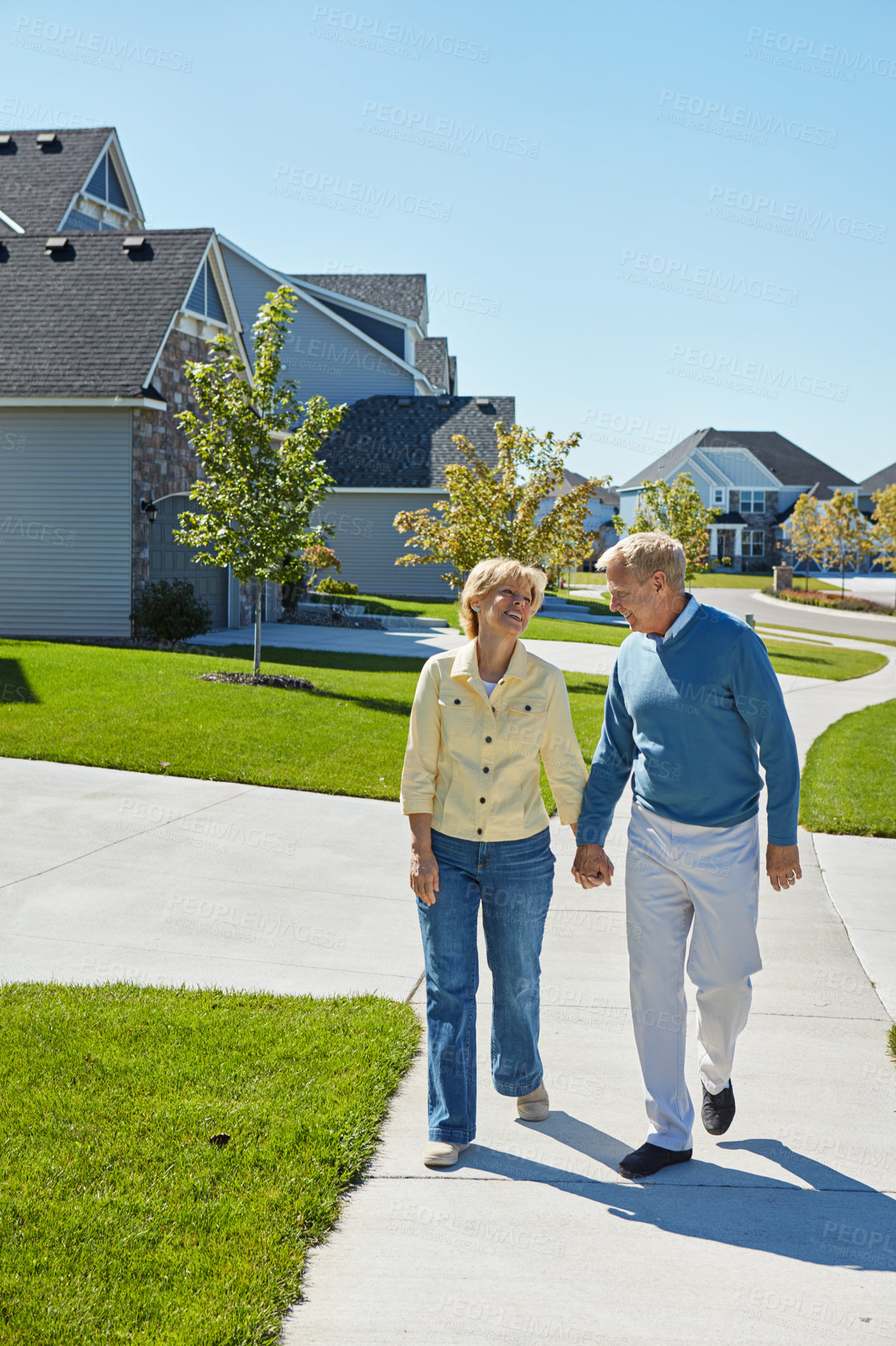 Buy stock photo Shot of a happy senior couple waking around their neighborhood together