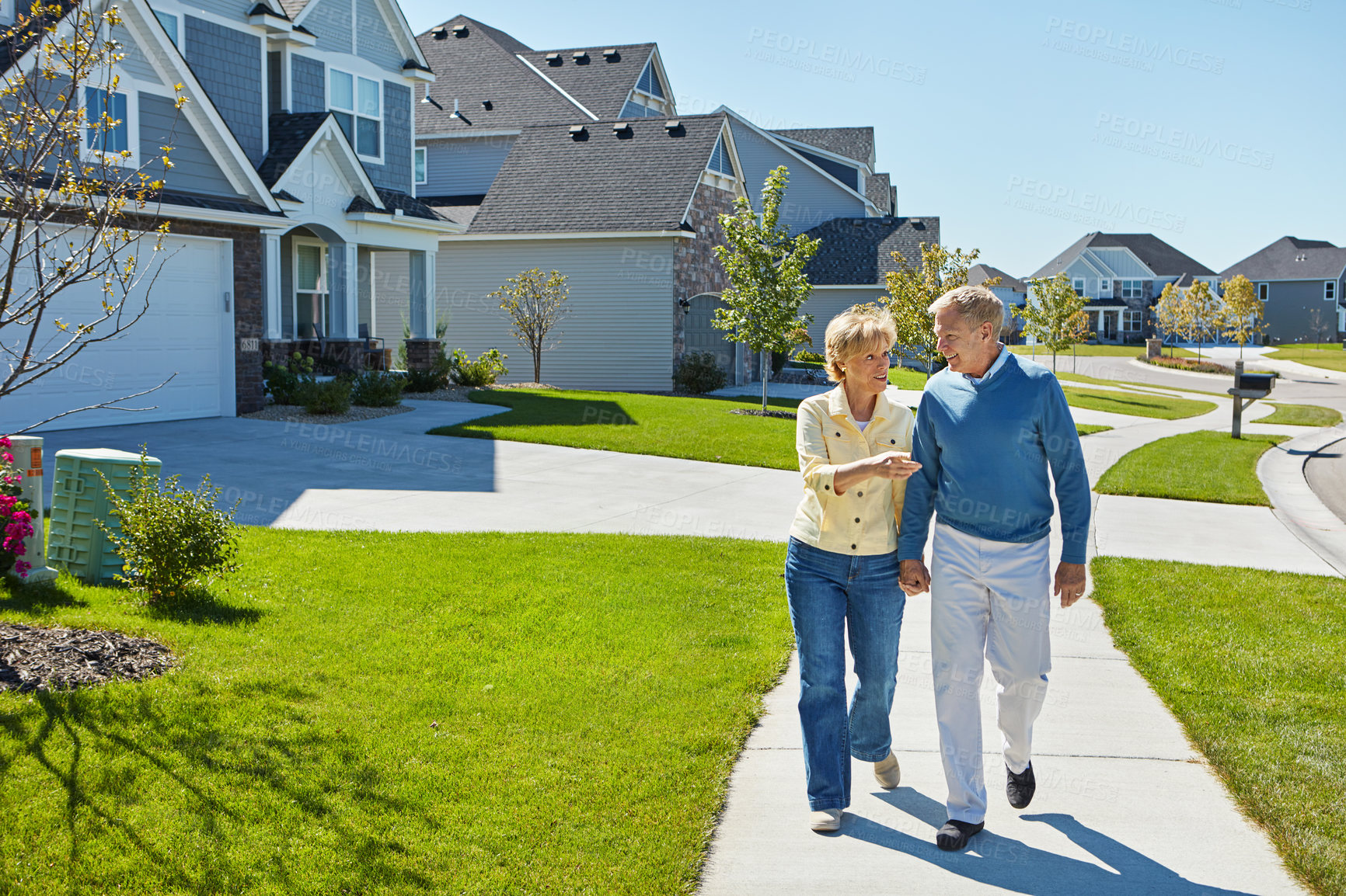 Buy stock photo Shot of a happy senior couple waking around their neighborhood together