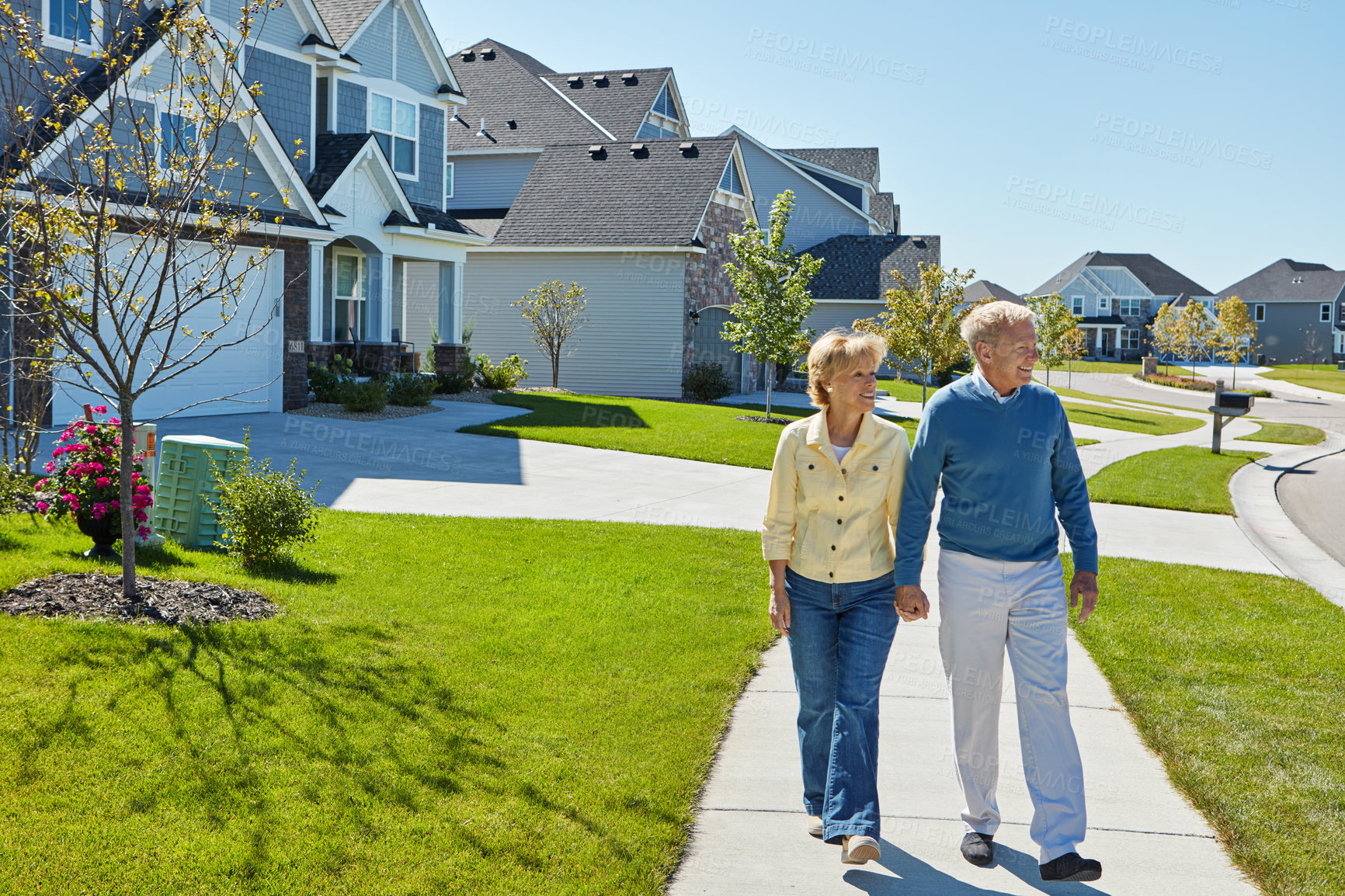 Buy stock photo Shot of a happy senior couple waking around their neighborhood together