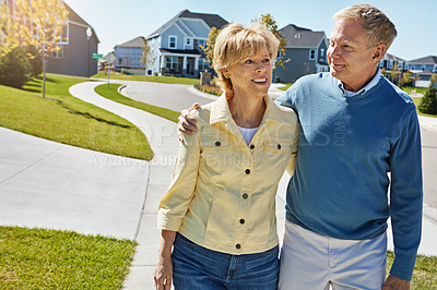 Buy stock photo Shot of a happy senior couple waking around their neighborhood together