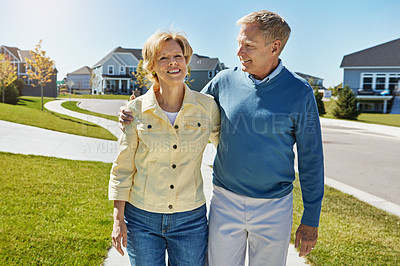 Buy stock photo Shot of a happy senior couple waking around their neighborhood together