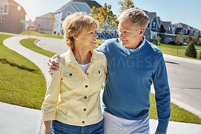 Buy stock photo Shot of a happy senior couple waking around their neighborhood together