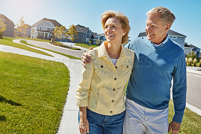 Buy stock photo Shot of a happy senior couple waking around their neighborhood together