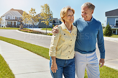 Buy stock photo Shot of a happy senior couple waking around their neighborhood together