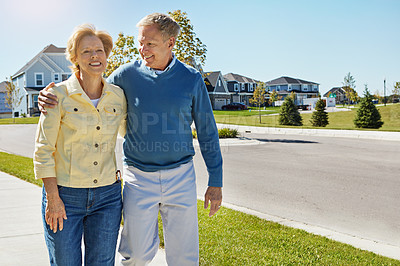 Buy stock photo Shot of a happy senior couple waking around their neighborhood together