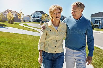 Buy stock photo Shot of a happy senior couple waking around their neighborhood together