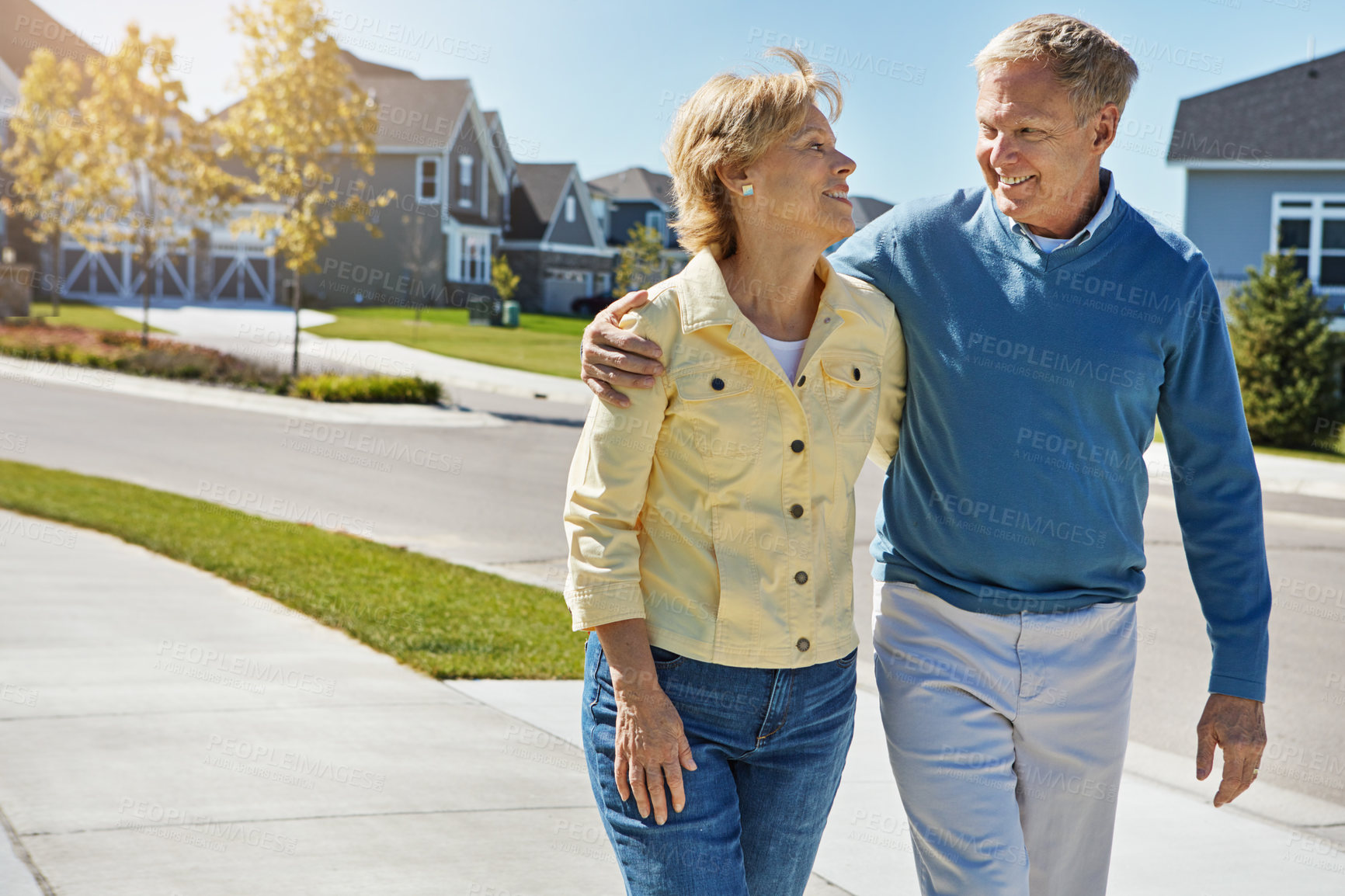 Buy stock photo Shot of a happy senior couple waking around their neighborhood together