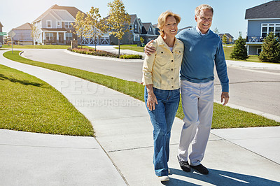 Buy stock photo Shot of a happy senior couple waking around their neighborhood together