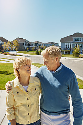 Buy stock photo Shot of a happy senior couple waking around their neighborhood together