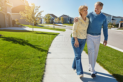 Buy stock photo Shot of a happy senior couple waking around their neighborhood together