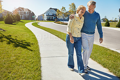 Buy stock photo Shot of a happy senior couple waking around their neighborhood together