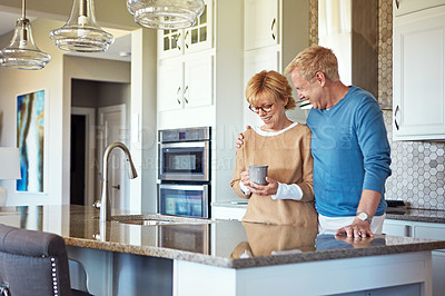 Buy stock photo Cropped shot of a mature couple having coffee in their kitchen