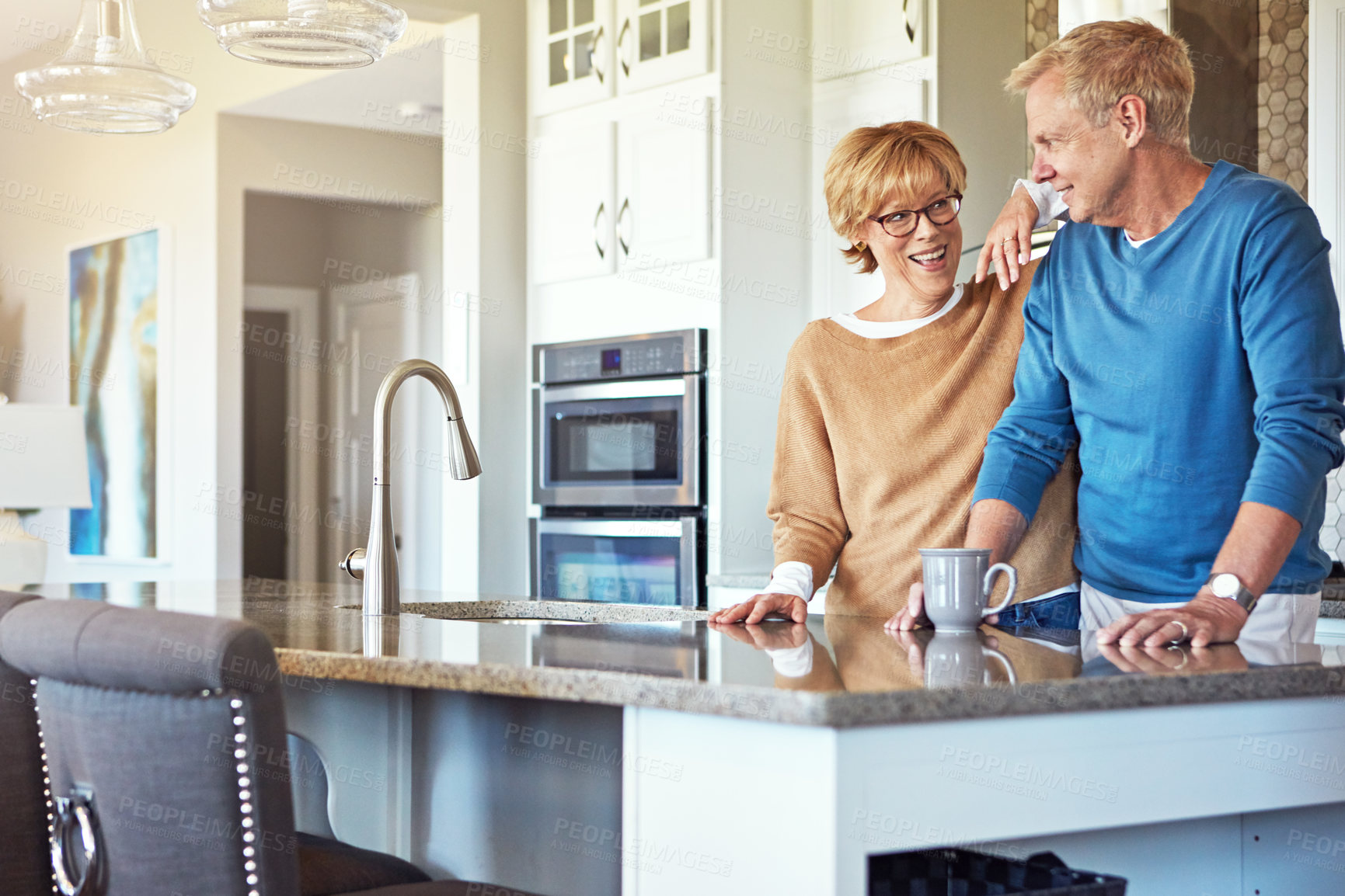 Buy stock photo Cropped shot of a mature couple having coffee in their kitchen