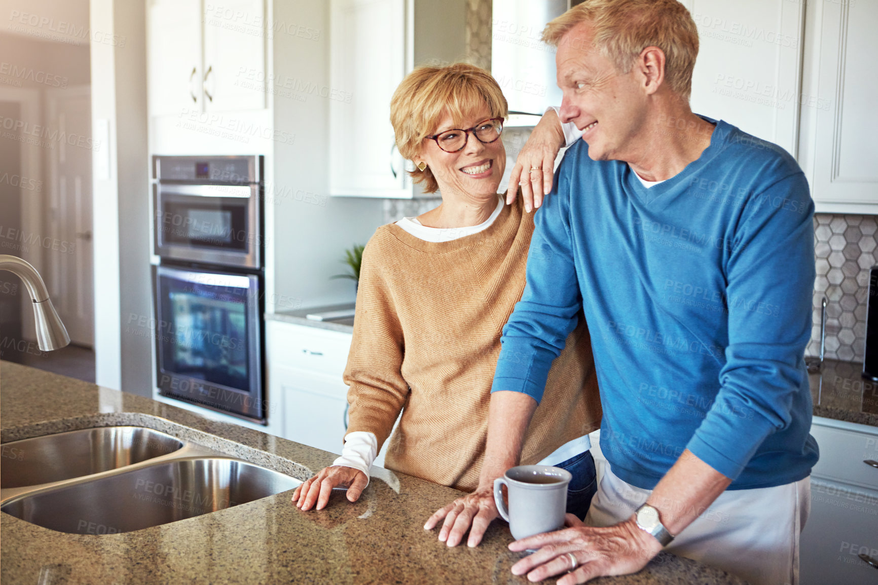 Buy stock photo Cropped shot of a mature couple having coffee in their kitchen