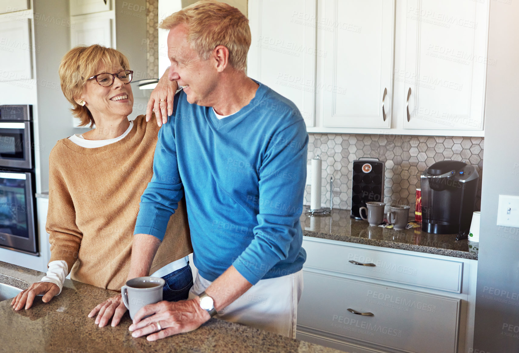 Buy stock photo Cropped shot of a mature couple having coffee in their kitchen