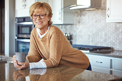 Buy stock photo Cropped portrait of a mature woman drinking coffee in her kitchen