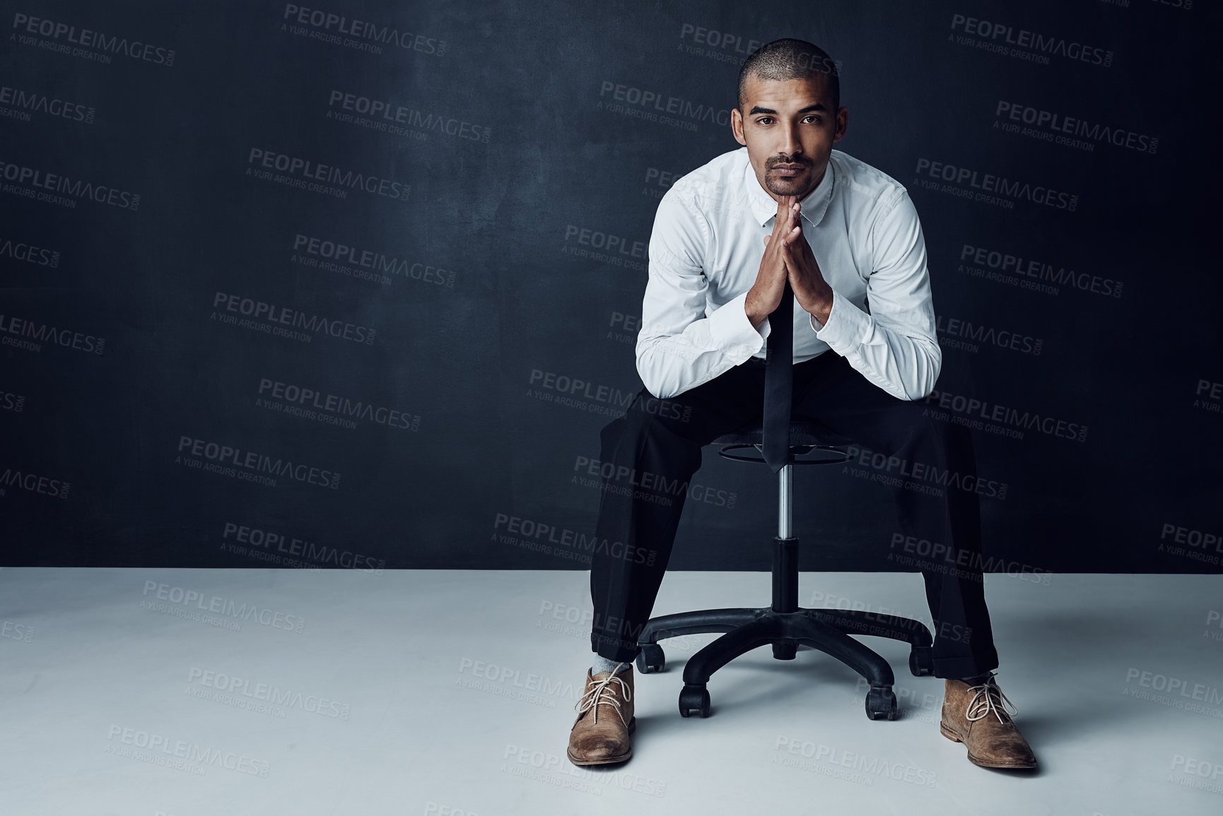 Buy stock photo Studio portrait of a confident young businessman against a dark background