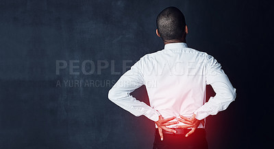 Buy stock photo Studio shot of a young businessman suffering with back pain highlighted in glowing red