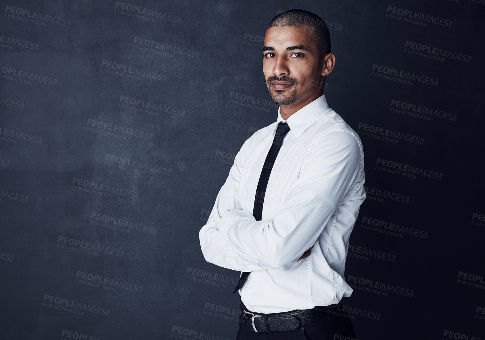 Buy stock photo Studio portrait of a confident young businessman against a dark background