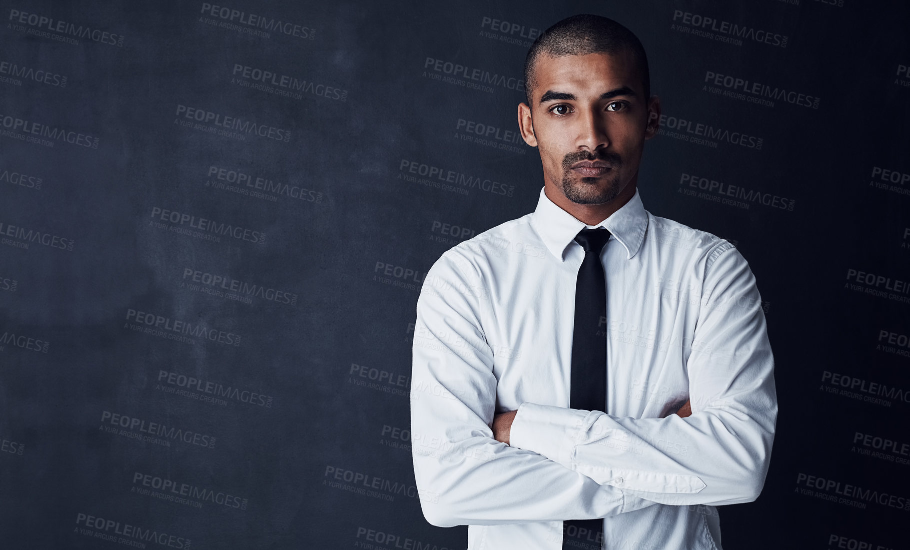 Buy stock photo Studio portrait of a confident young businessman against a dark background