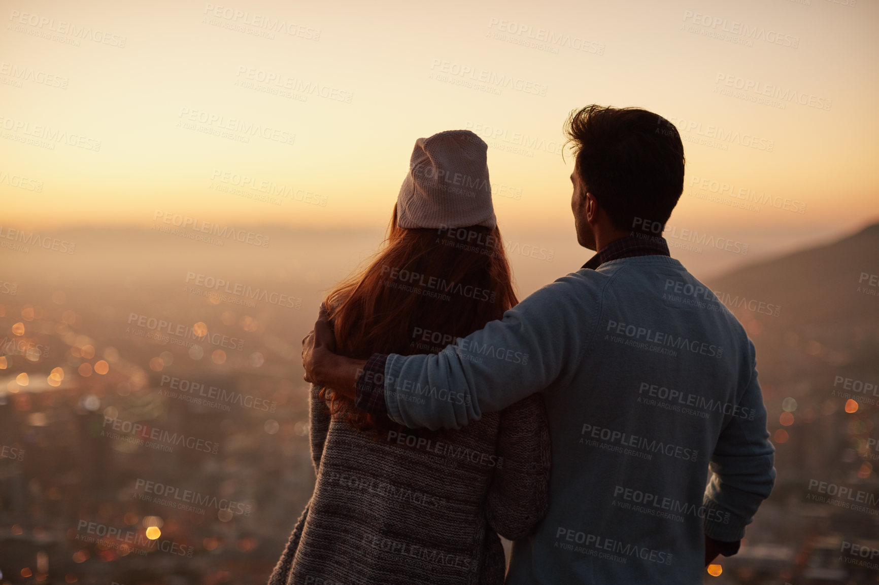 Buy stock photo Rearview shot of an affectionate  young couple admiring a city view at dawn