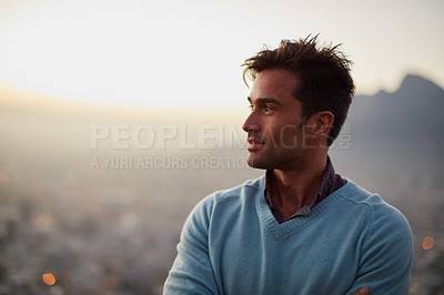 Buy stock photo Shot of a happy young man posing in front of a city view