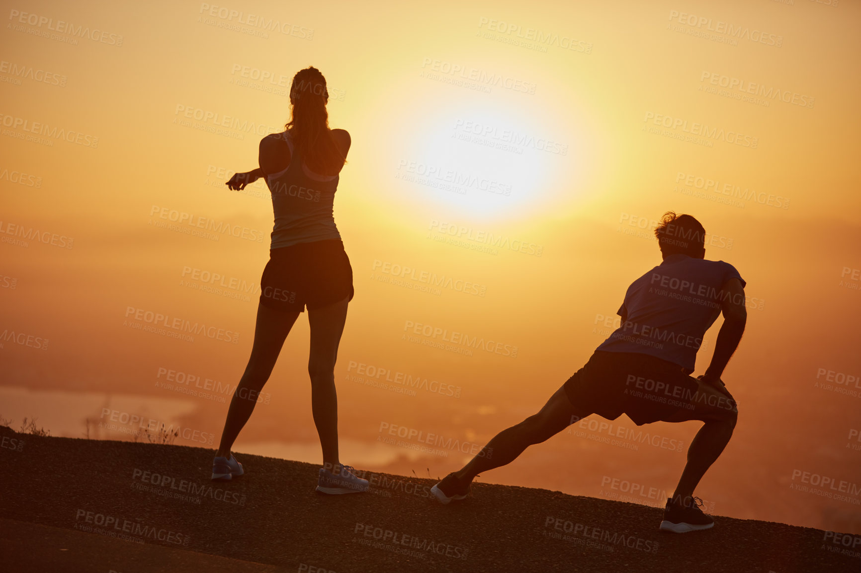 Buy stock photo Shot of a silhouetted couple out for a run at sunrise