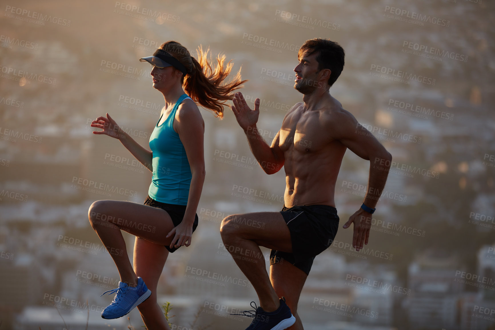 Buy stock photo Shot of an athletic young couple exercising above the city in the morning