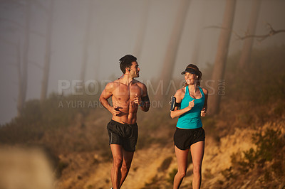 Buy stock photo Shot of an athletic young couple out for a run in the morning