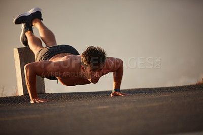 Buy stock photo Shot of a handsome shirtless man working out outside