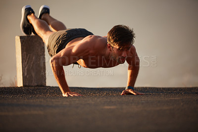 Buy stock photo Shot of a handsome shirtless man working out outside